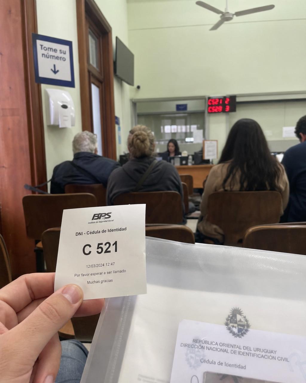 Holding a number ticket in a Uruguayan public office waiting room